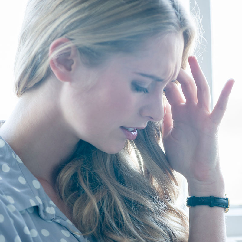 Woman holding head in pain because she has Surfer's Ear.